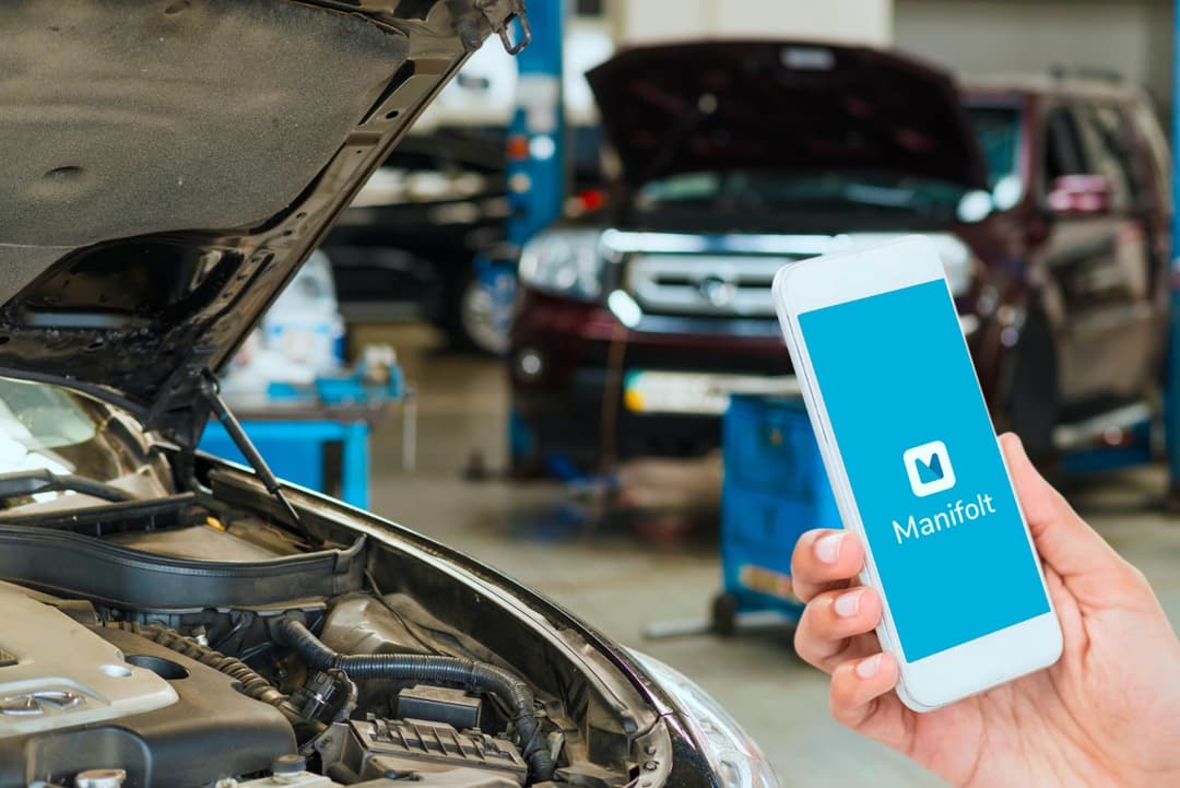 a person using a phone in front of a car